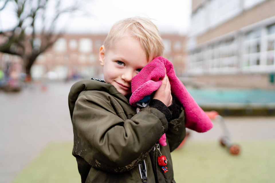 Jongetje met doek tegen hoofd op schoolplein